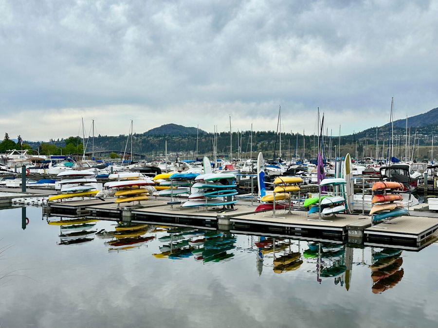 Kelowna downtown marina with kayaks and boats moored beside waterfront condos on Okanagan Lake